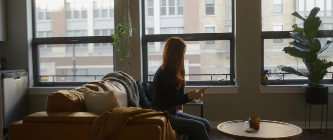 A woman uses a phone on the couch