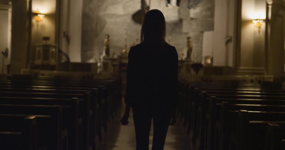 Woman walking down the middle aisle of a church
