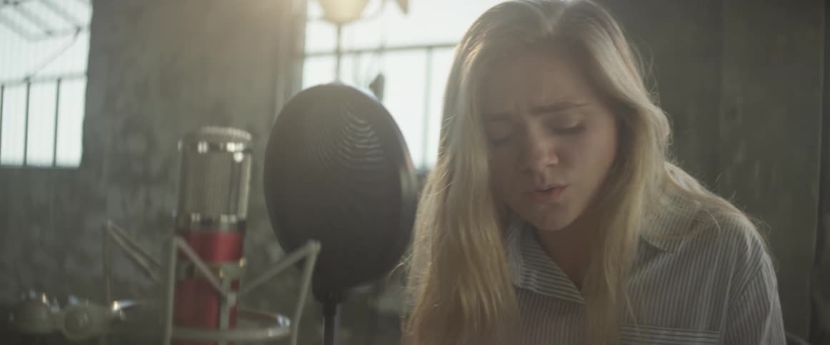 Woman sings into a microphone