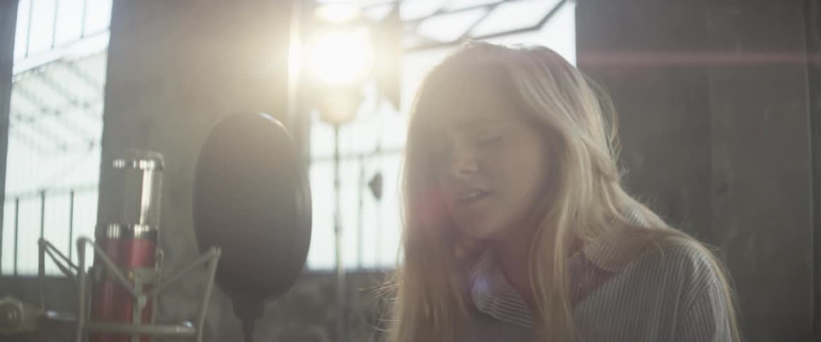 A woman is singing into the microphone