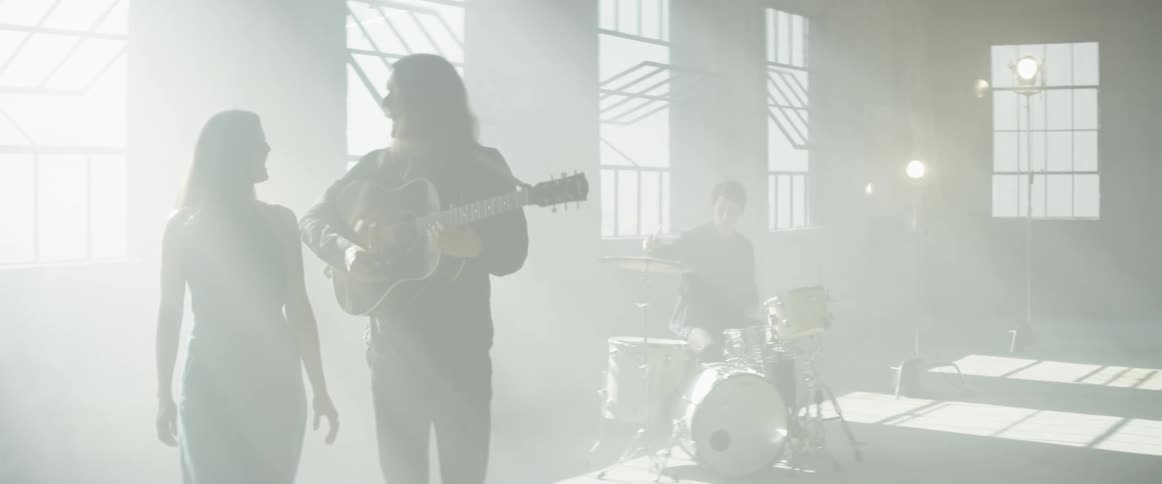 A band plays a song and sings in the sunlight coming through windows