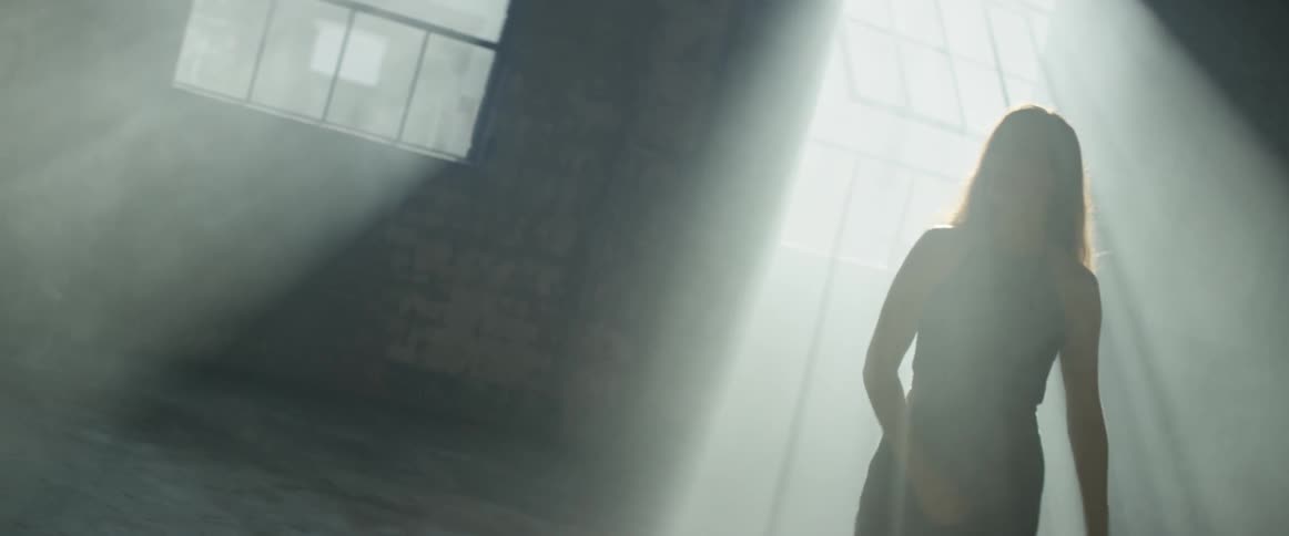 Woman swings her arms as she stands in the sun's rays