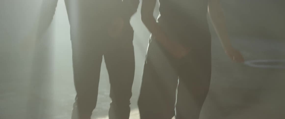 A man and woman dance in the sunlight coming through a window