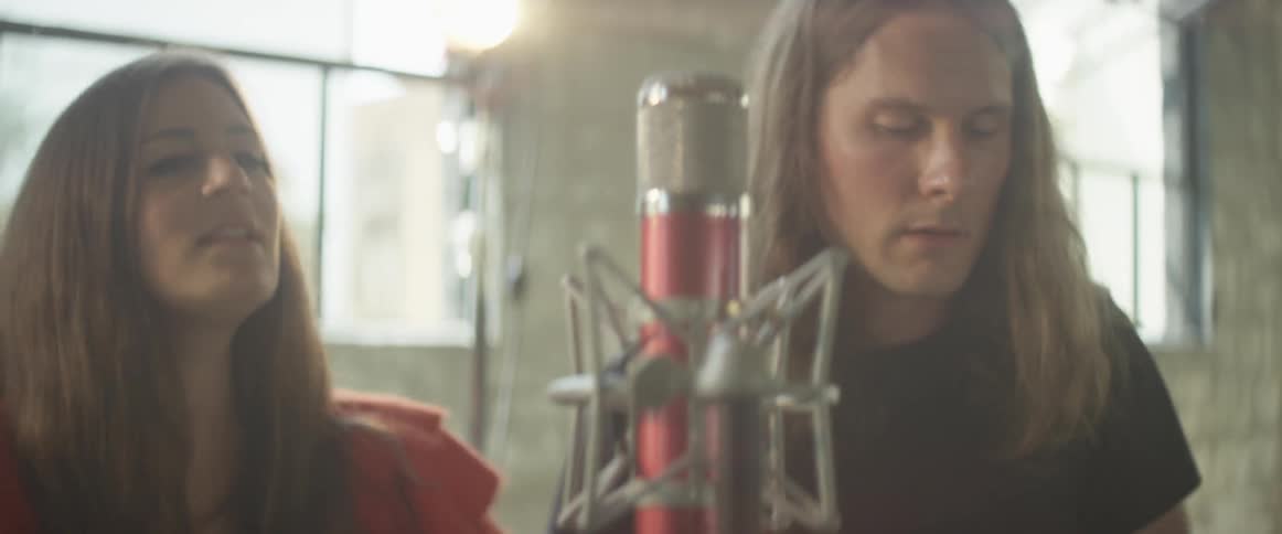 People sing together in front of a microphone