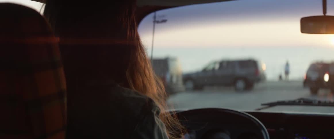 A woman drives towards the beach