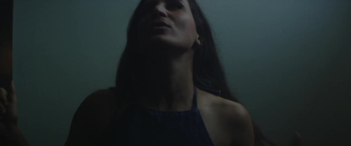 A woman dances around in the dark room