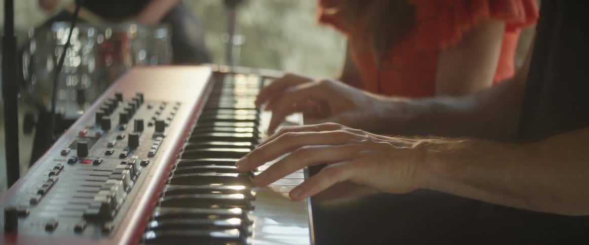 A person is playing the keyboard next to someone