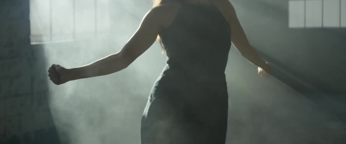 A woman is dancing in the dark room