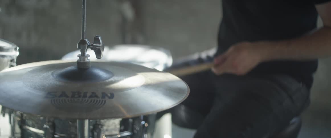 Man hits cymbals with a drumstick