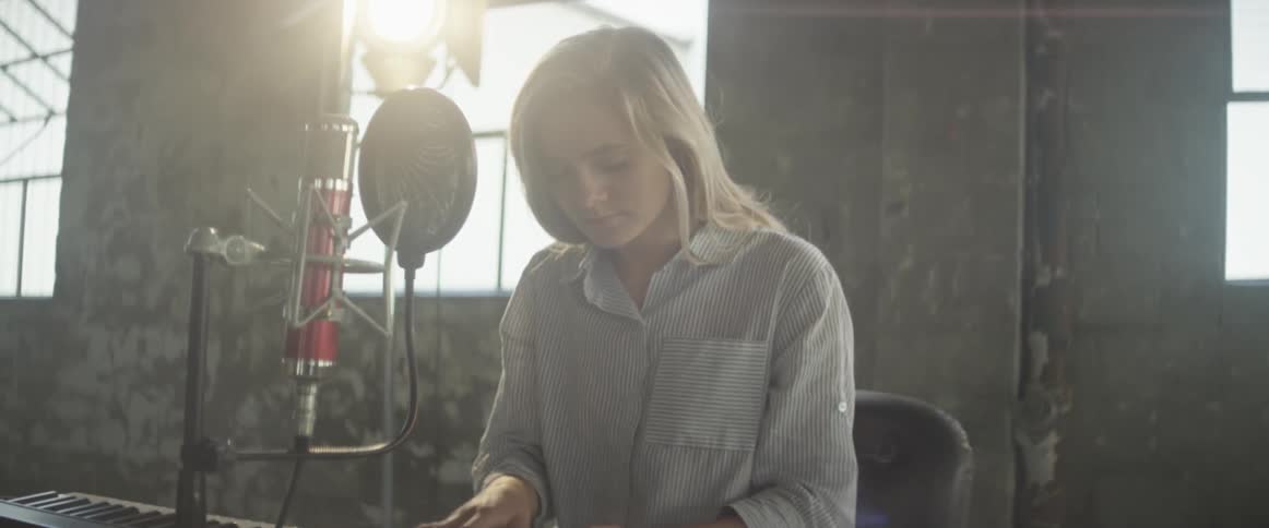 A woman plays a keyboard in a recording session