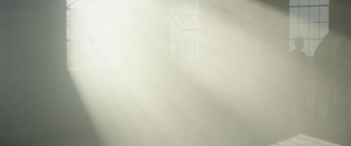 People walk in the room full of sunlight from the windows