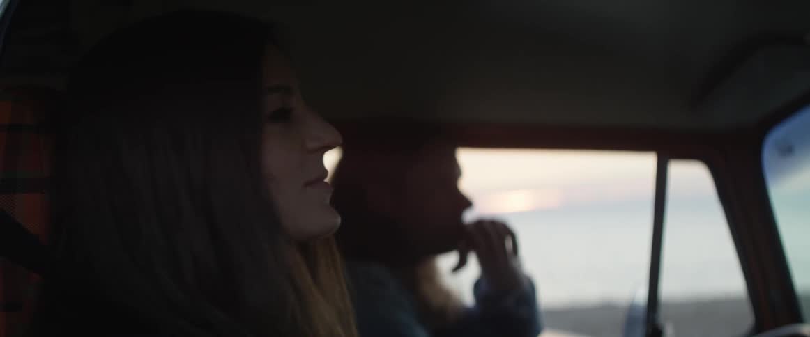 A woman looks out the window then turns back to the driver