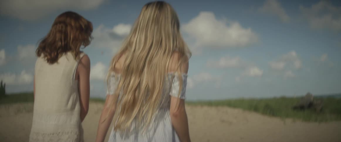 Two women walk together on the beach