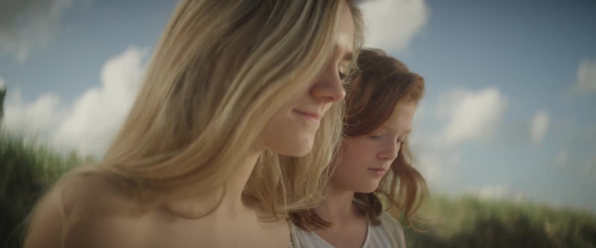 Two young women walk onto the beach