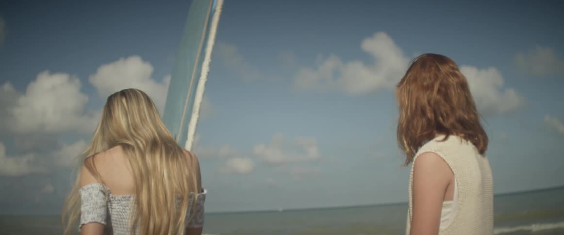 Two women ride on a sailboat on the ocean