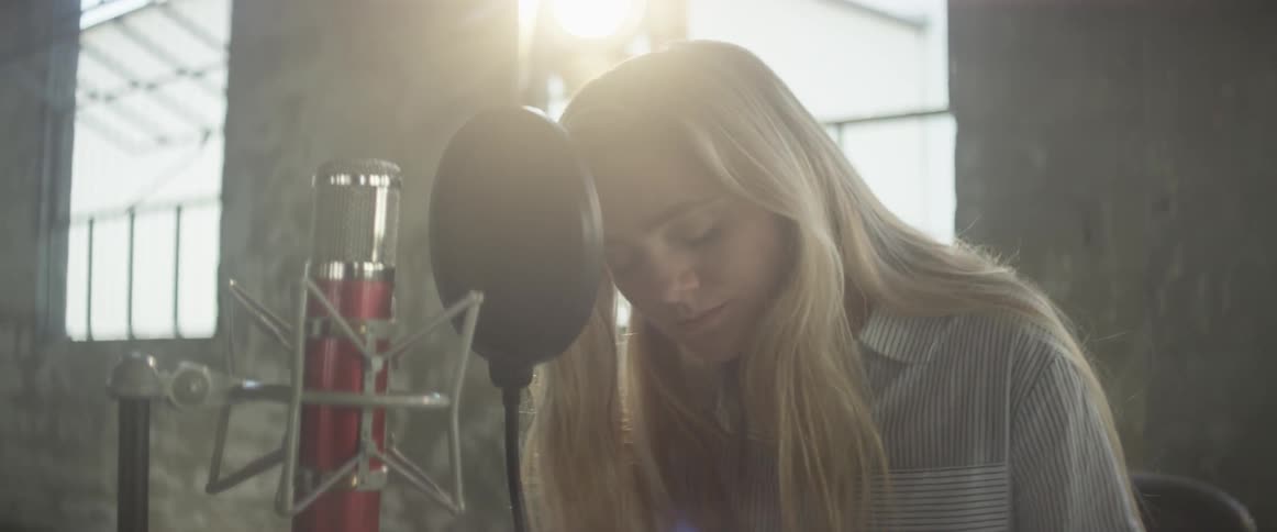 Woman sings into a microphone