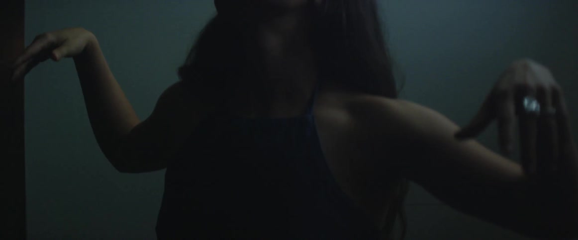 A woman raises her arms and tilts her head as she dances