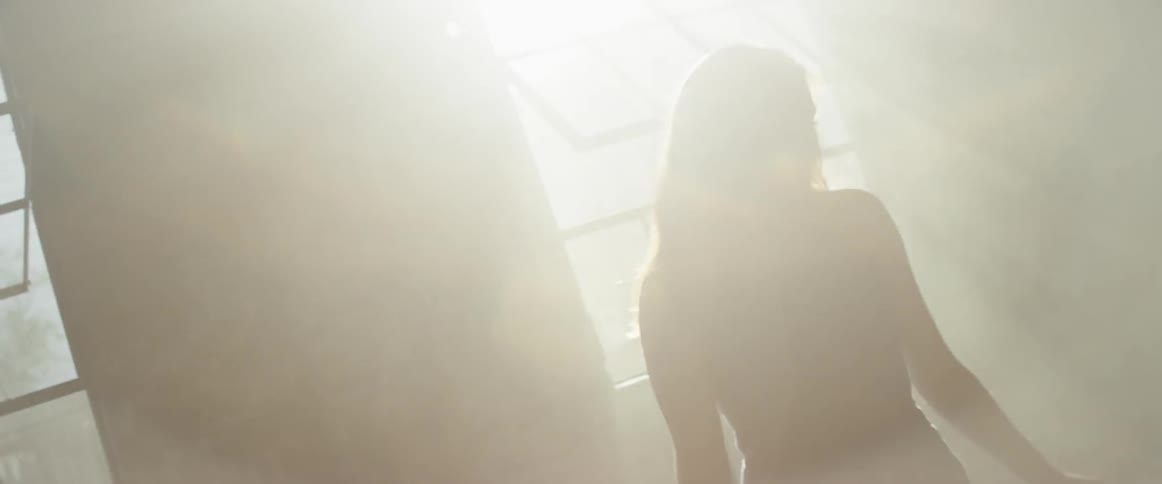 Woman walks in a room through the sun's rays