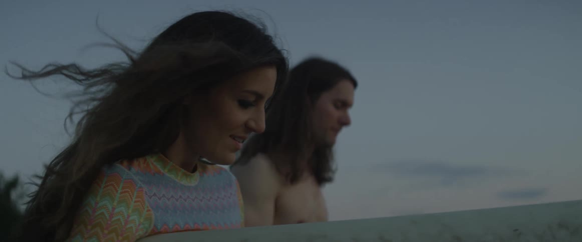 Man and woman walk outside at sunset