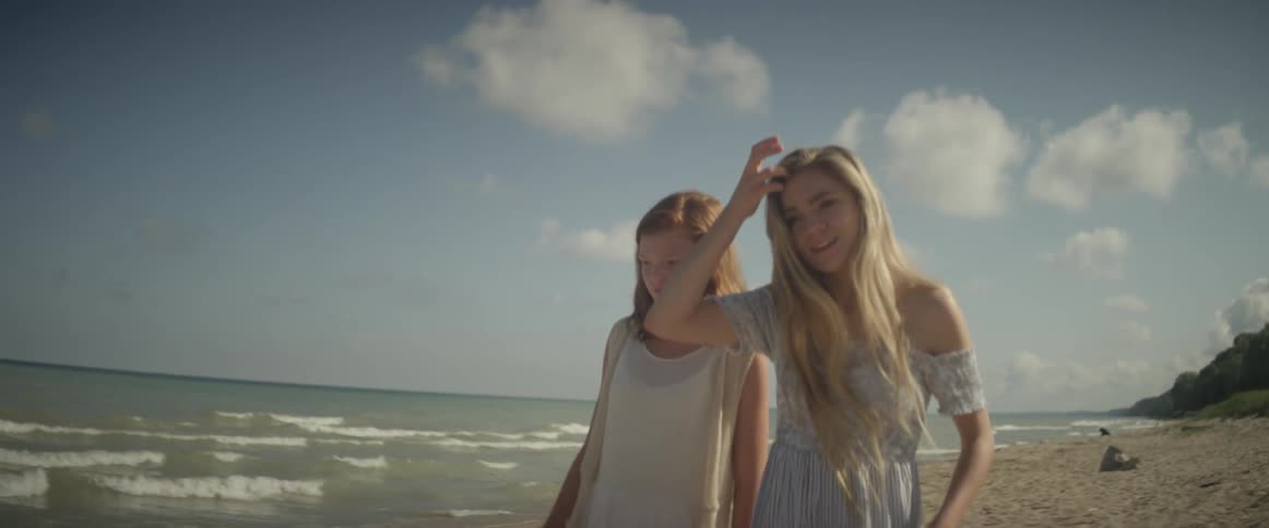 Two women walk on the sandy beach