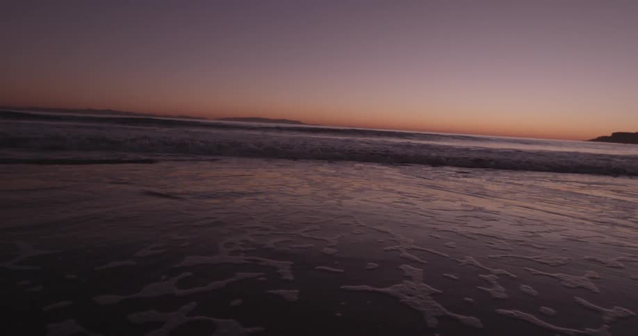 Waves lapping on shore during sun set