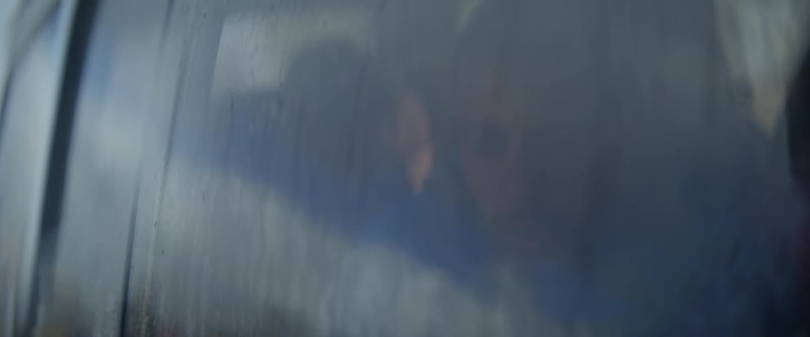 Man sits in a vehicle and looks out the dirty window