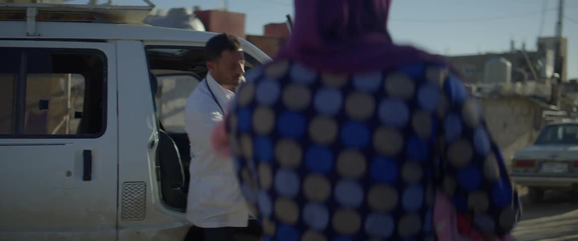 Man exits a white van as a woman with a baby approaches