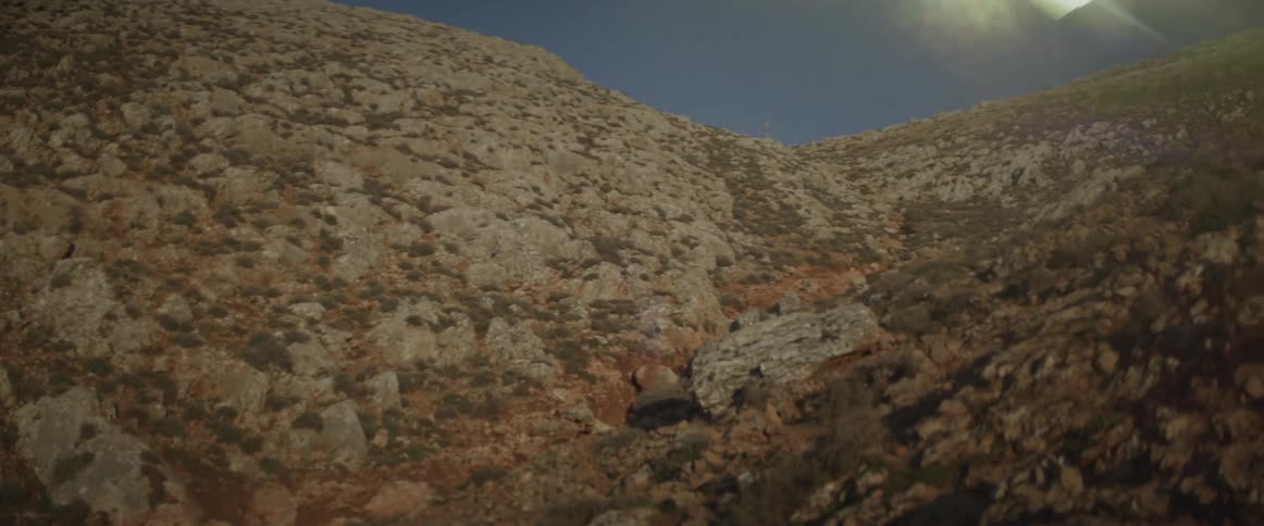 Light flashes over rocky hilly landscape