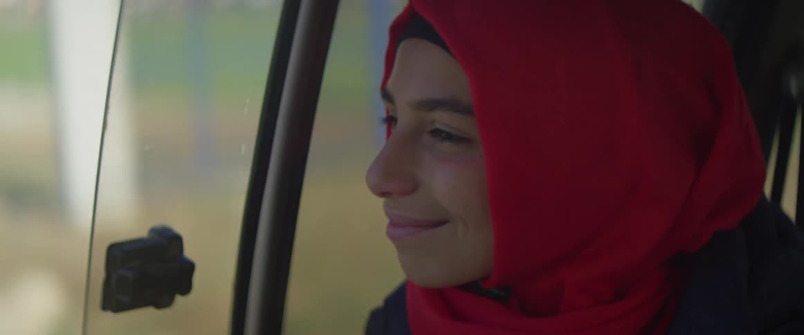 A woman smiles as she rides in the vehicle