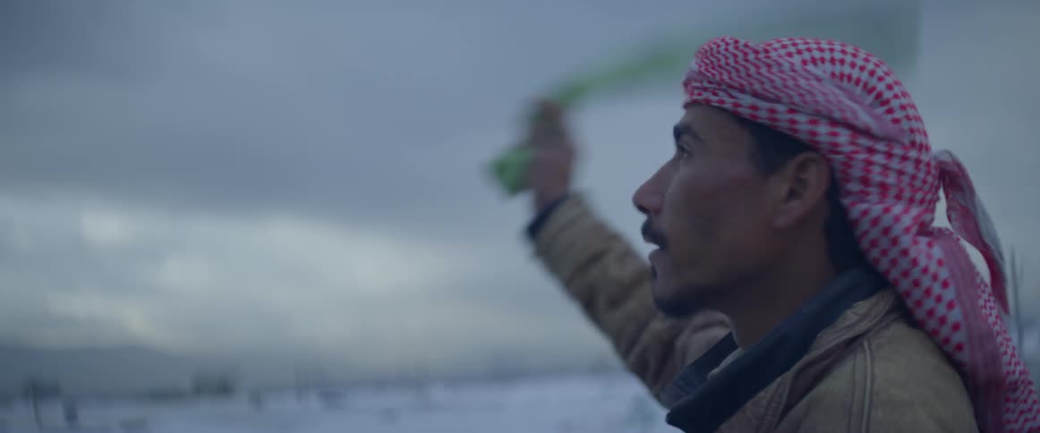 A man signals by waving a towel and whistling on a cloudy day