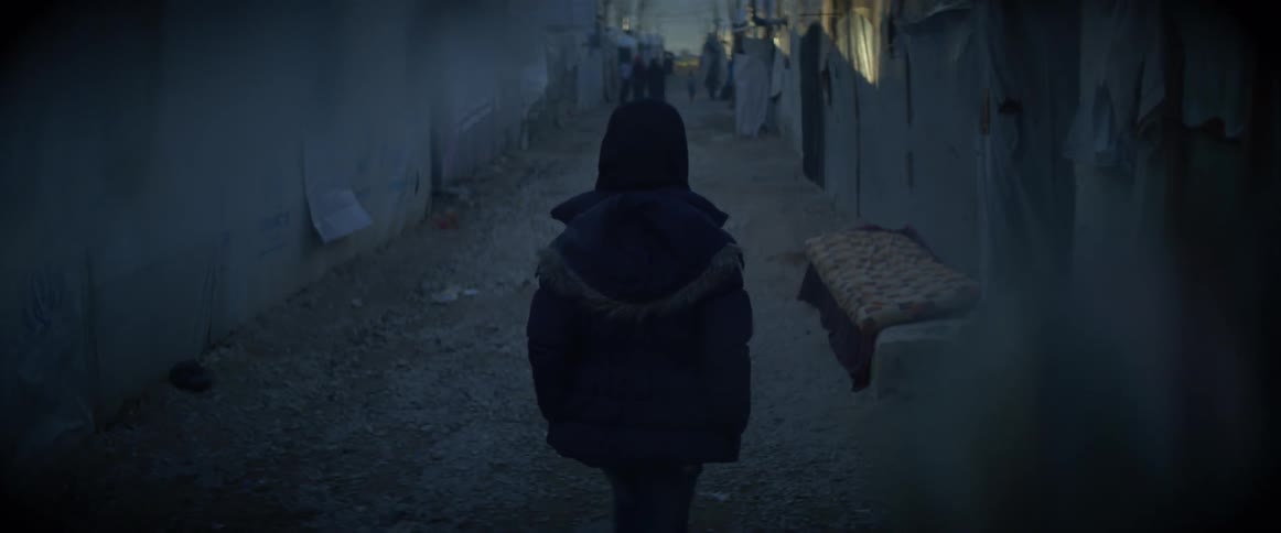 Woman wearing a hooded jacket walks down a path