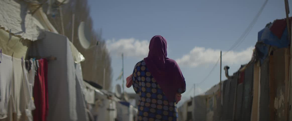 Woman wearing a red scarf walks down the road