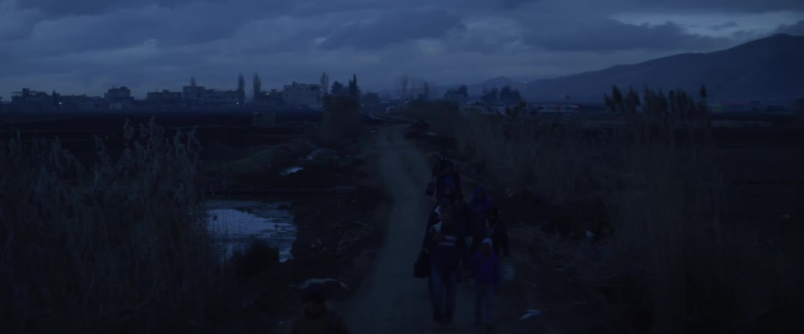 Refugees are traveling on a dirt road at night