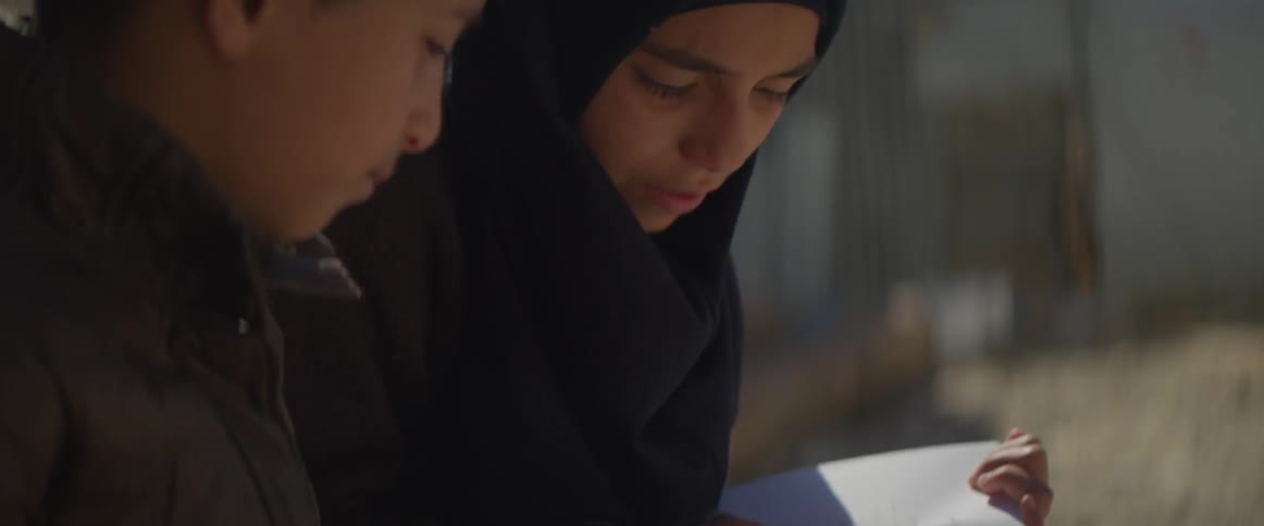 Two people sitting and reading a book