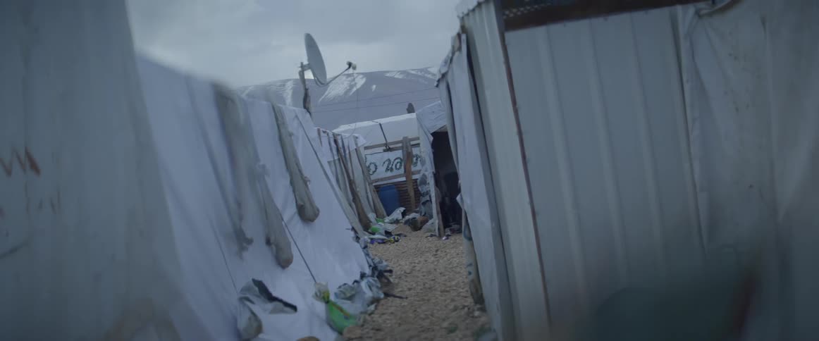 Clouds are hovering in the sky above a refugee camp in winter