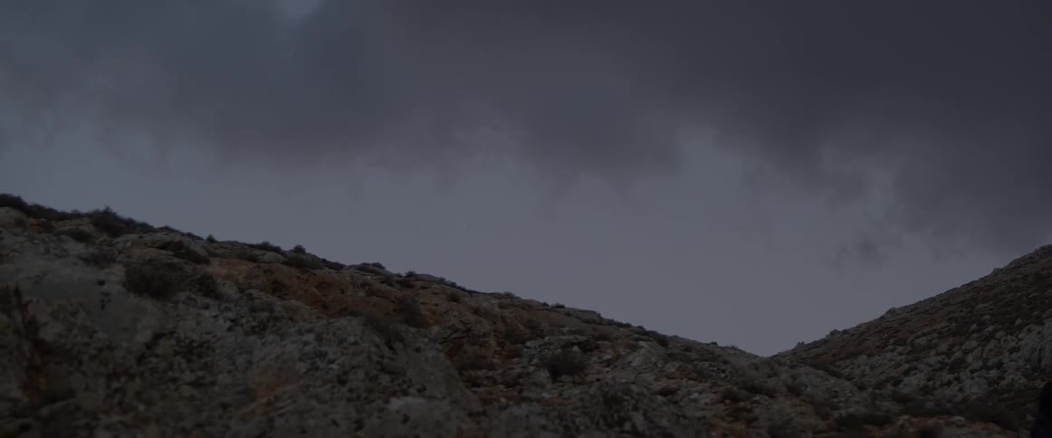 Clouds roll over a hill in the evening
