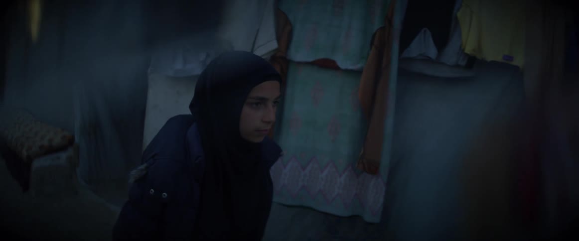 Woman walks through a village in the evening
