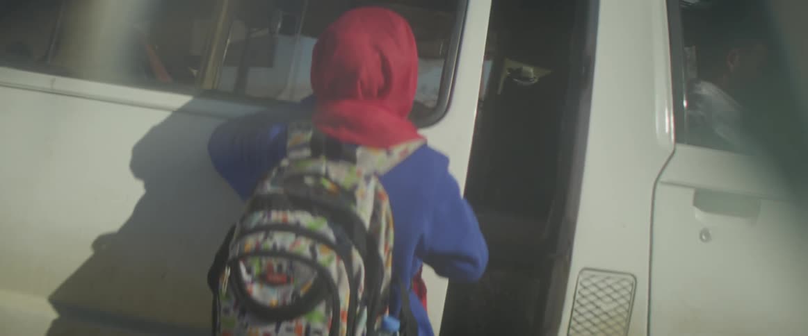 Person walks to a white vehicle