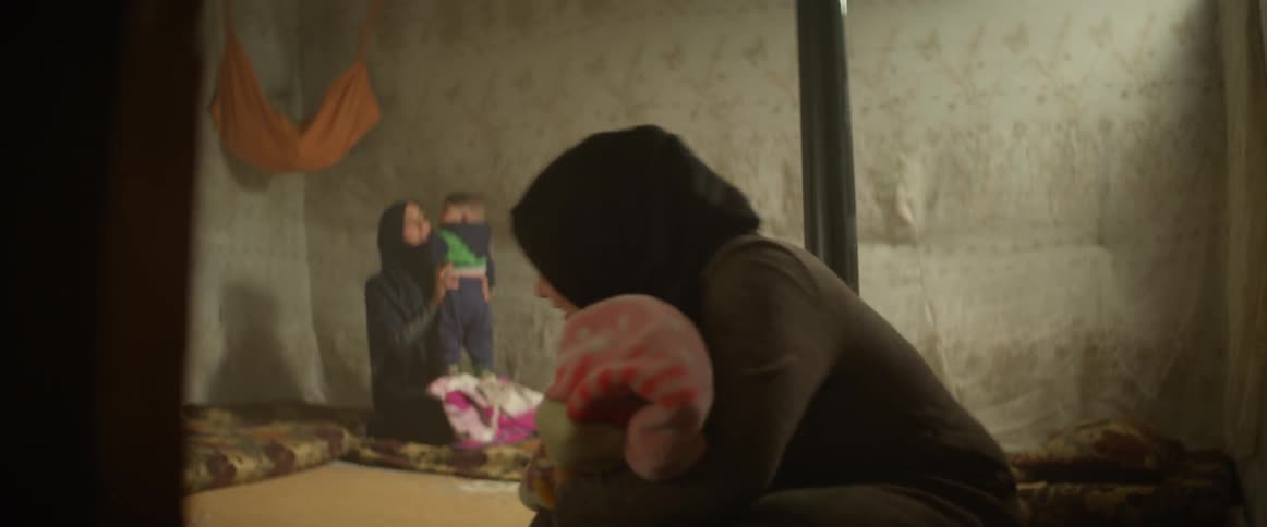 A woman looks over to another woman holding a child