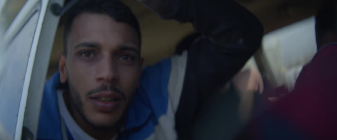 Man closes the door of a vehicle while looking outside