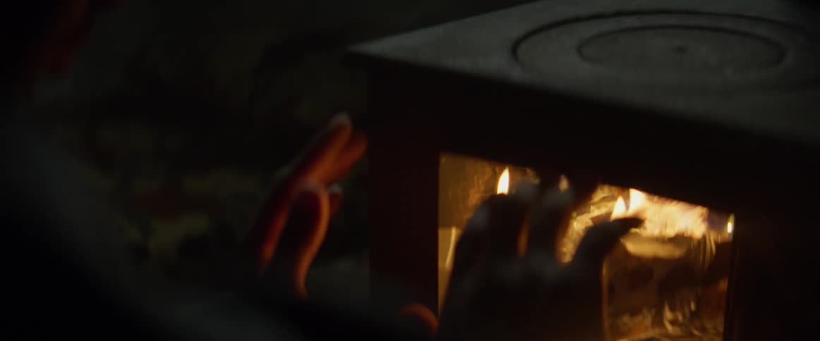 Person warms their hands on the fire