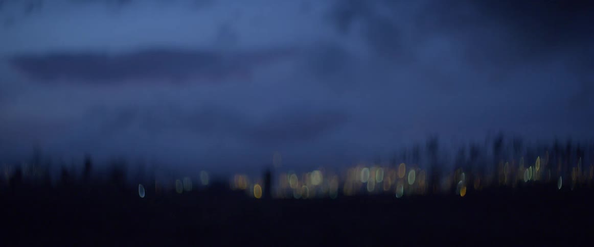 Clouds billow in the sky over a city at night