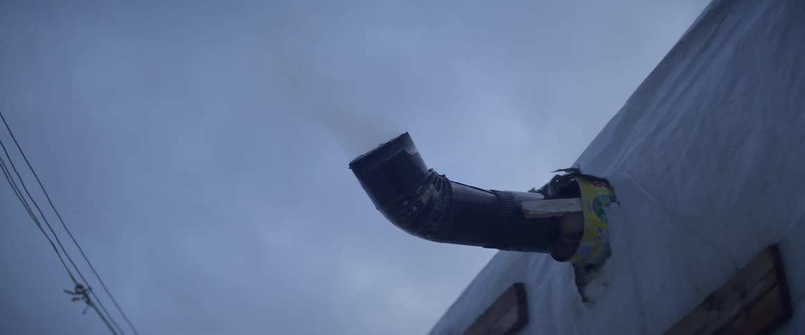 The pipe coming from the building gives off steam