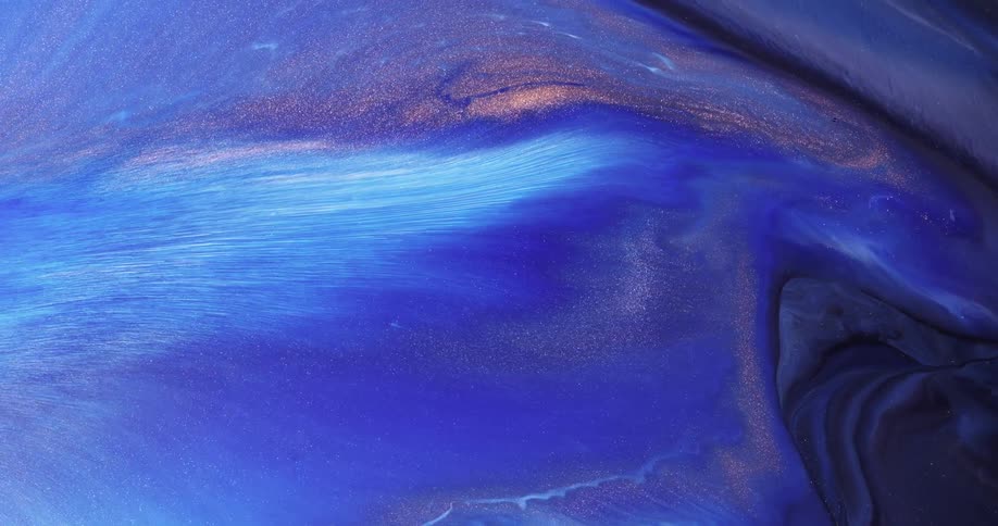 Different colors of liquid swirl and mix together