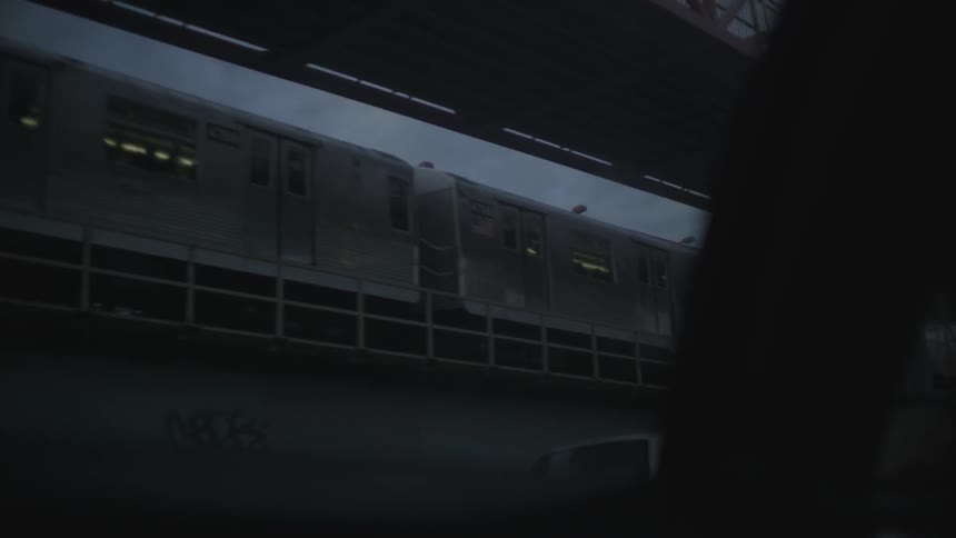 Traffic moves along the road while the elevated train passes above
