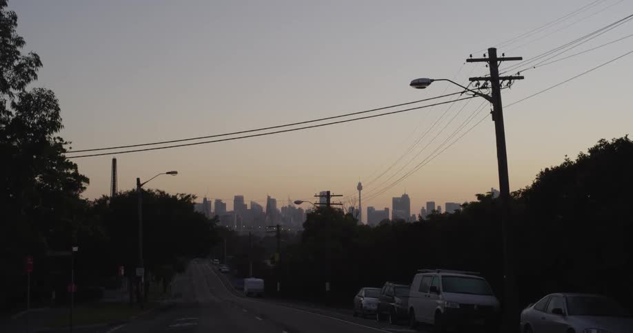 Cars parked on a quiet city street at sunset