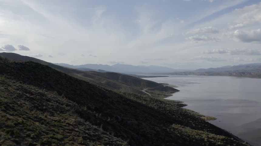 Sun rises over a hill and a body of water