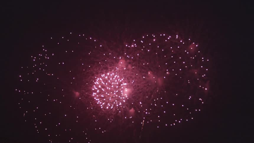 Fireworks explode in a night sky