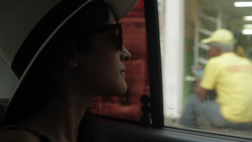 A woman riding through an urban area in a car