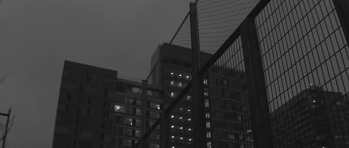 Lights shining from the windows of a large city building at night